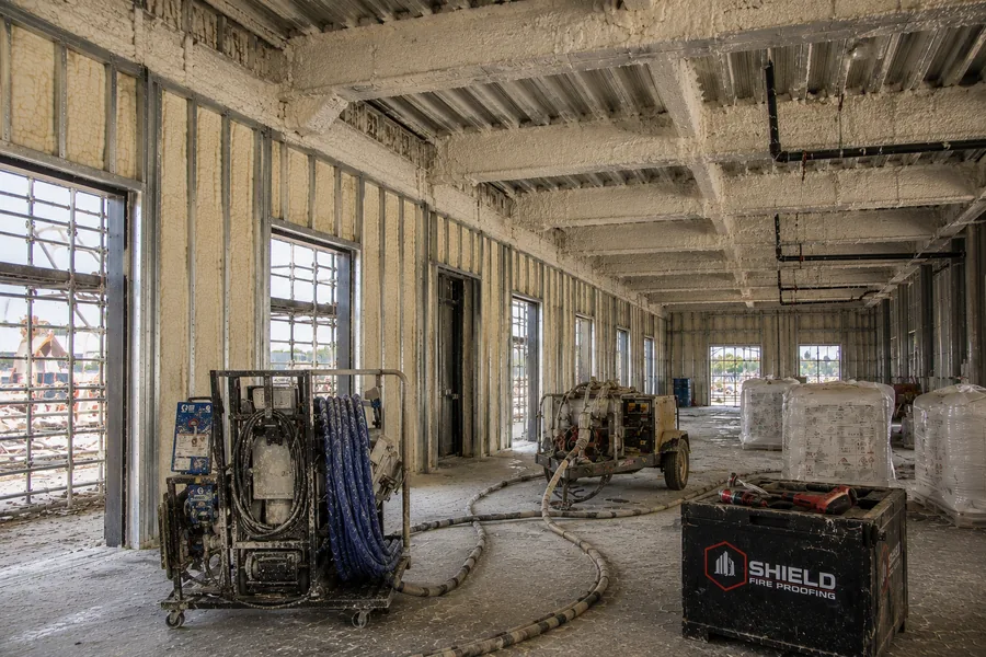 Shield spray equipment and material staged inside a building under construction.